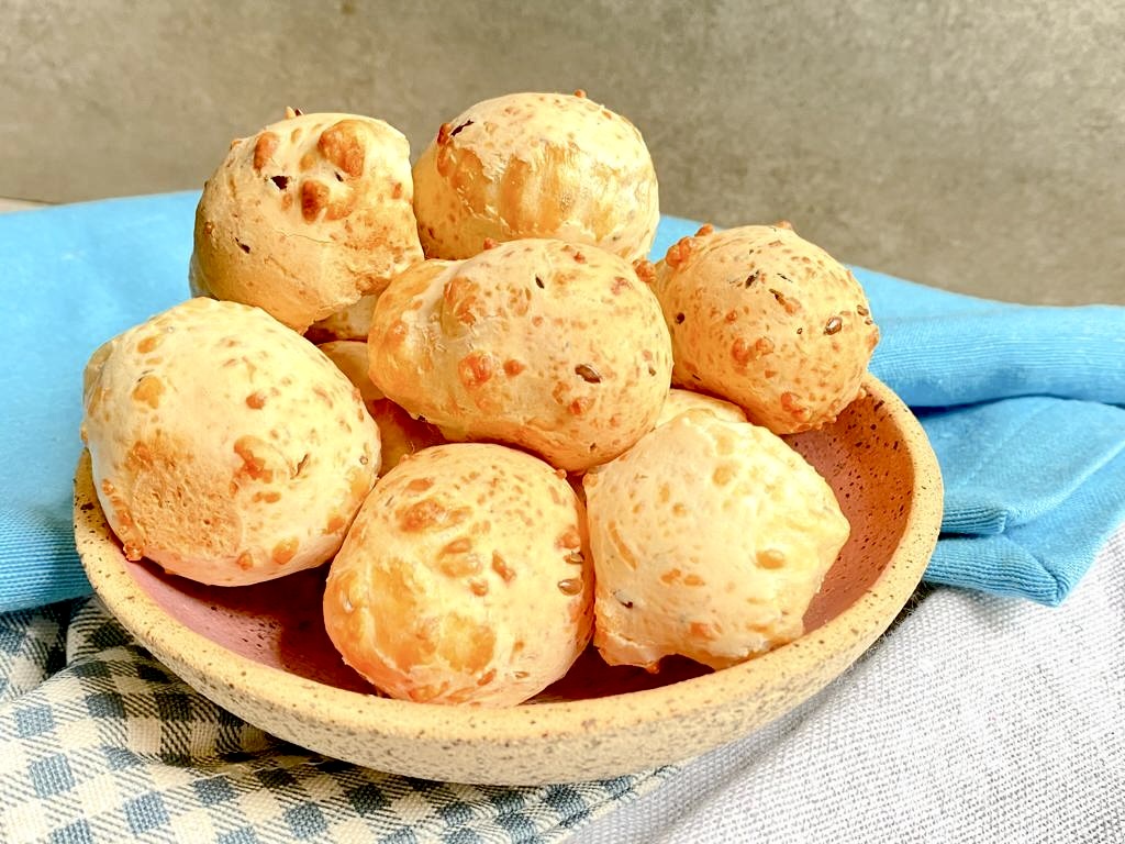 Pão de Queijo, a traditional Brazilian cheese bread made with tapioca flour and cheese, offering a soft, chewy texture and a rich, cheesy flavor.