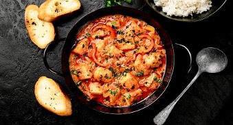 A vibrant bowl of Brazilian moqueca seafood stew, made with fish, shrimp, coconut milk, and spices.