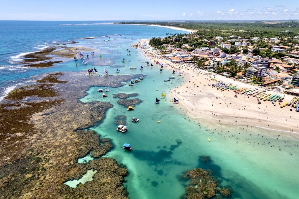 A vibrant view of Porto de Galinhas, with its clear turquoise waters, natural pools, and stunning coastline, located in Pernambuco, Brazil.
