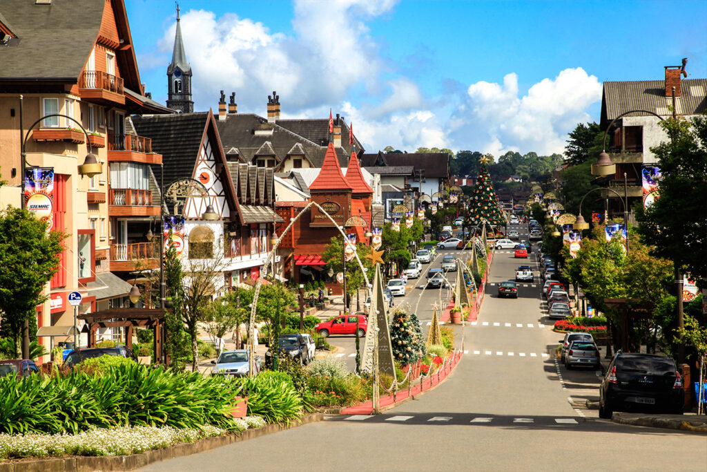 A picturesque view of Gramado’s architecture, featuring charming alpine-style buildings surrounded by lush greenery, reflecting the town's unique cultural fusion.