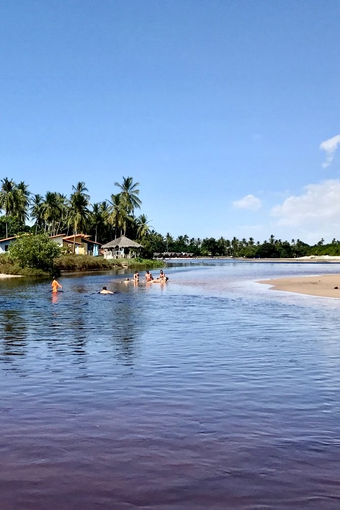 A serene landscape of Santo Amaro, located within the Lençóis Maranhenses National Park, showcasing its stunning sand dunes and tranquil lagoons under the clear sky.