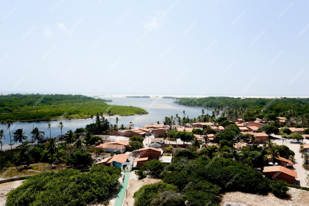 A breathtaking view of Barreirinhas, the gateway to the Lençóis Maranhenses National Park, with its vast sand dunes and crystal-clear lagoons under the bright blue sky.