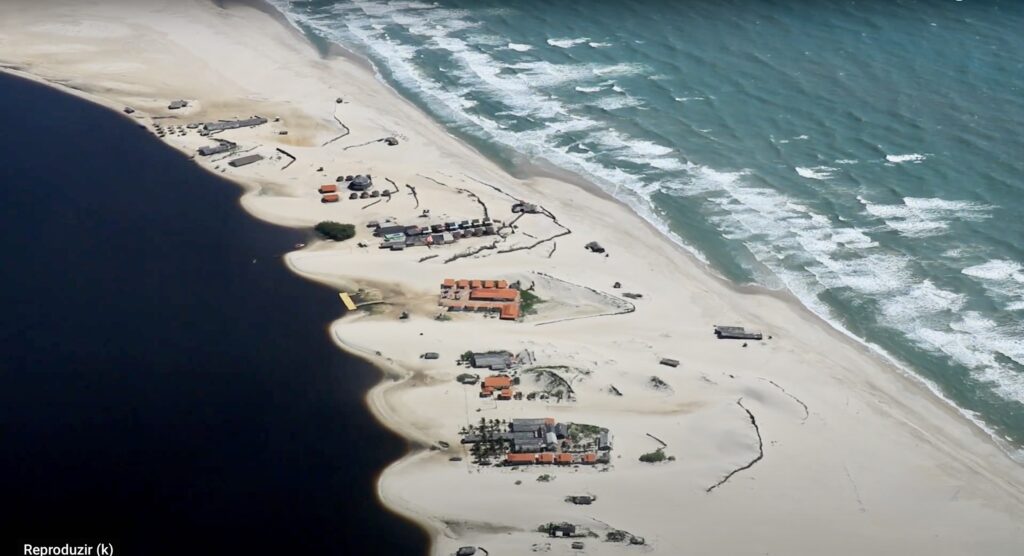 A scenic view of the Preguiças River flowing towards the Caburé Beach, with its peaceful waters and lush surroundings, offering a serene escape in the Lençóis Maranhenses region.