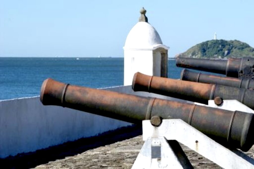 Ancient cannons at Fortaleza de Nossa Senhora dos Prazeres on Ilha do Mel, Brazil, pointing toward the ocean, a reminder of the island’s colonial past.