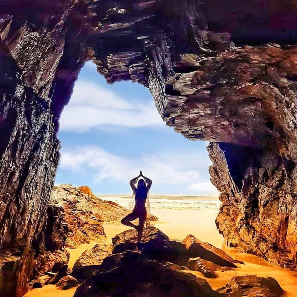 View from inside Gruta das Encantadas on Ilha do Mel, Brazil, framing the blue ocean and sky through its rocky entrance.